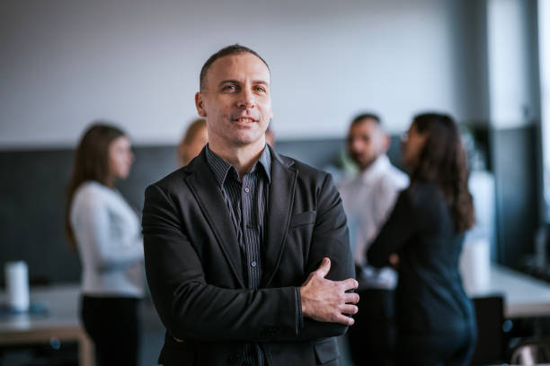 istock Confident professional standing in a business environment with team collaboration 2192225508