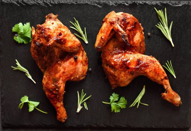 istock Grilled half chicken on black slate plate 2192225519