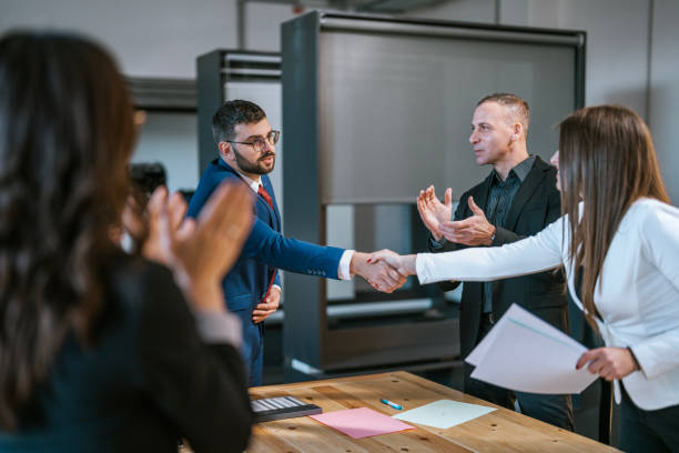 Colleagues shaking hands in an office after a successful meeting