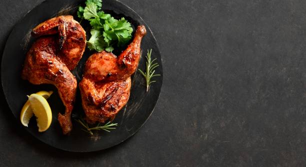 istock Roasted half chicken on black wooden board 2192225685