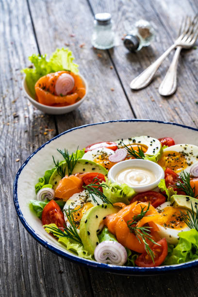 istock Smoked salmon with hard-boiled egg, avocado and leafy vegetables on wooden table 2192226402