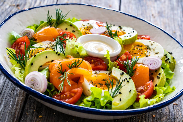 istock Smoked salmon with hard-boiled egg, avocado and leafy vegetables on wooden table 2192226458
