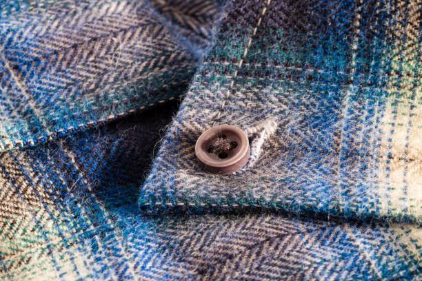 istock Close-up of a textured button on a blue plaid fabric. 2192227359