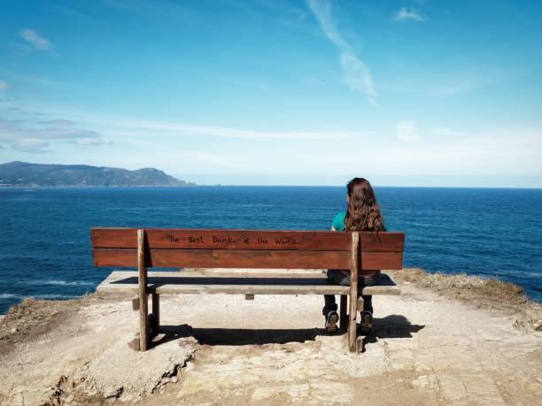 istock Woman on a bench with ocean view. 2192228001