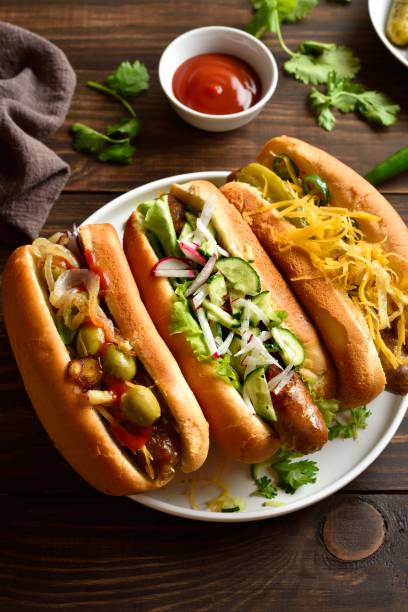 istock Hot dogs with different toppings on wooden table 2192228643