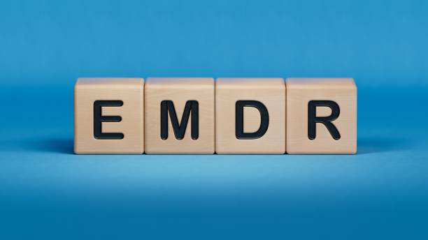 istock The text EMDR word Eye Movement Desensitization is written on notepad . Medical concept.close up of wooden elements,Business Concept.3D rendering on blue background. 2192230228