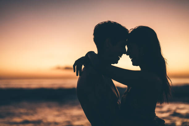 istock Couple embracing at the beach during a romantic sunset silhouette 2192230321