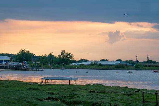 istock Calm river flows through a serene landscape, bathed in warm sunset light. 2192232343