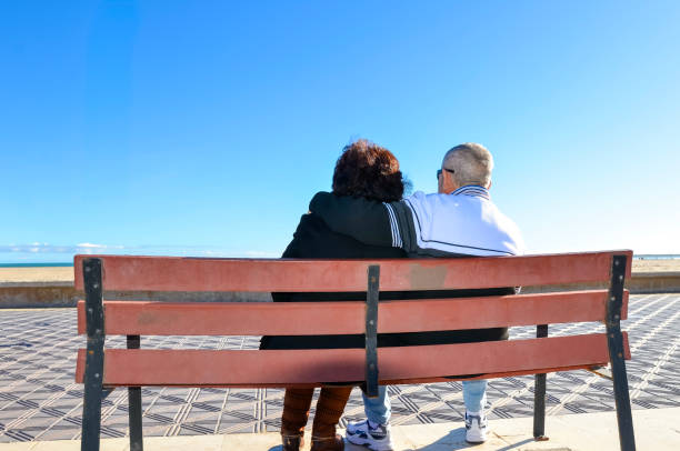 istock Elderly couple embracing on bench overlooking tranquil ocean vista 2192232520