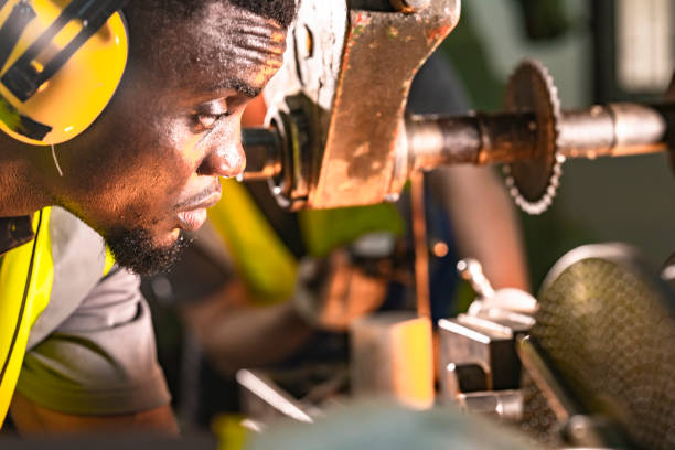 istock Focused industrial technician operating heavy machinery with precision. Wearing ear protection and safety gear, the professional works in a brightly lit workshop, emphasizing safety and expertise. 2192234092