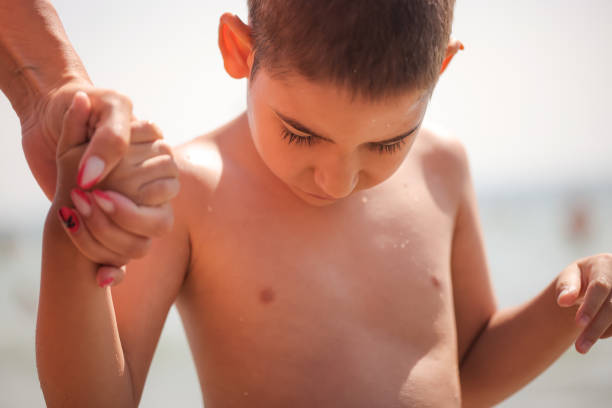 A close-up of a boy with a mental disability gently holding his mother's hand, showing a loving bond.