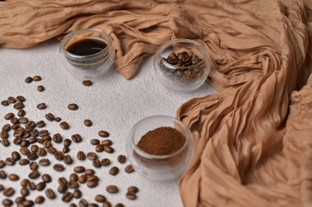 istock Fresh aromatic grain, ground and coffee drink in a small glasses, white background, brown cloth 2192235303