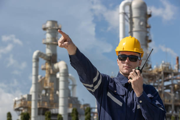 istock Man professional engineer technician wear safety uniform and white hard hat working area near tank refining oil petrochemical industry factory. Industrial factory site energy power station. 2192235568