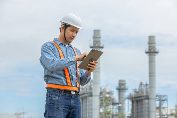 istock Man engineer with tablet working factory producing electricity oil energy. Construction manager oil refinery in petrochemical. improvement inspector Industrial worker working power plant. 2192235587