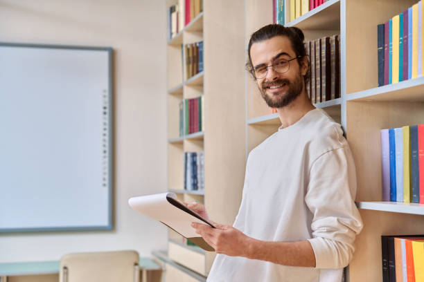 istock Portrait young male with clipboard in library 2192237665