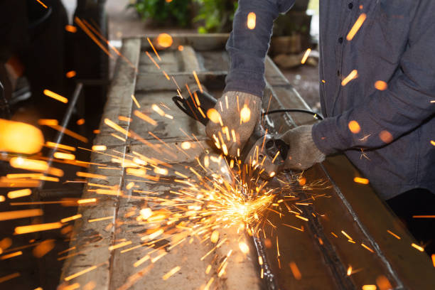 istock Heavy Industry Engineering Factory Interior with Industrial Worker Using Angle Grinder and Cutting a Metal Tube. 2192239191