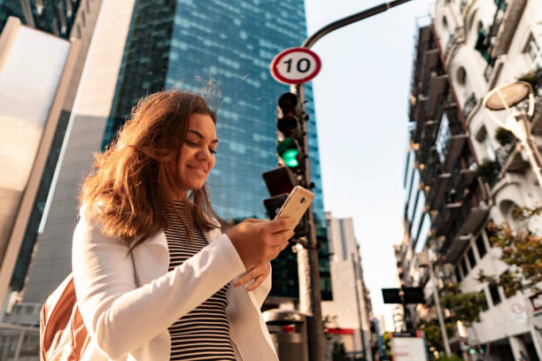istock Woman using smartphone near traffic light 2192239676