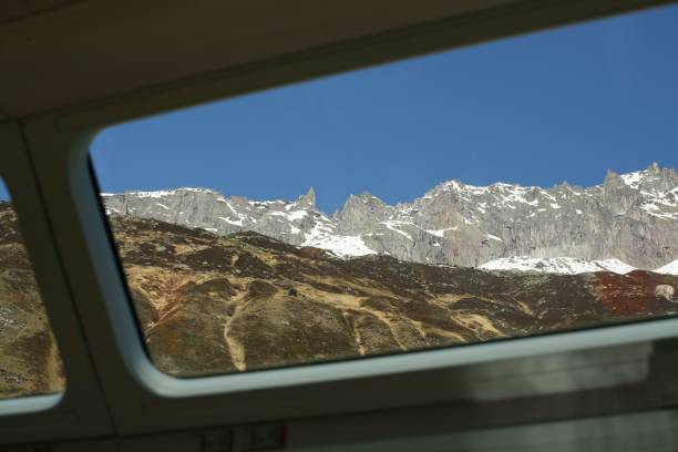 istock View of snow-capped mountain peaks under a blue sky seen through the window from inside the train. 2192243403