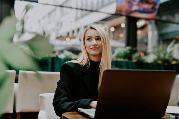 istock Beautiful Female Freelancer Working From Co-working Space Smiling As She's Looking Outside Window 2192247916