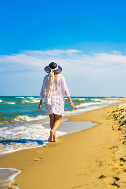 istock Beautiful mature woman walking on sandy beach 2192250117
