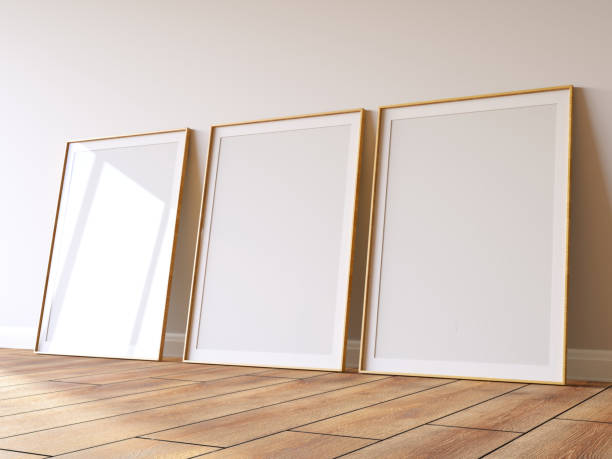 istock Three Empty Mock Up Picture Frames on Parquet Floor Against White Wall 2192253840