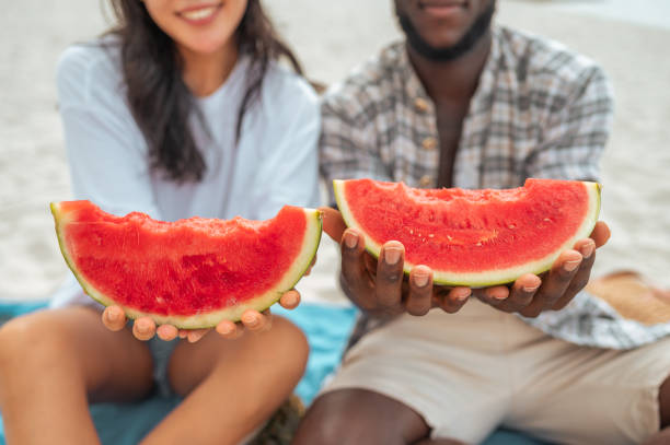 istock Diverse Couple Enjoys Watermelon Slice at Beach 2192257942