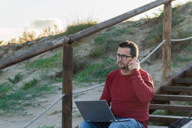 istock A man digital nomad working on a laptop and taking voice notes on the phone 2192260451