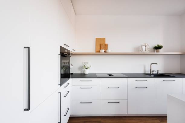 istock Modern Minimalist Kitchen with White Cabinets and Black Countertops 2192260622