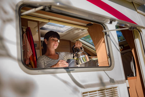 Woman cooking in camper, motorhome interior RV