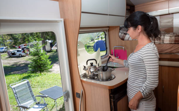 Woman cooking in camper, motorhome interior RV