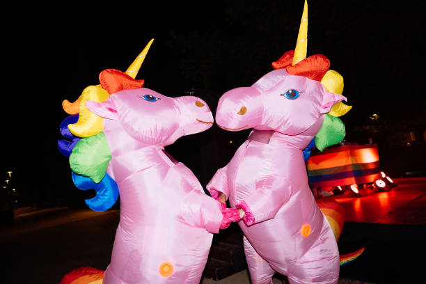 istock Two inflatable unicorns holding hands at night during pride event 2192262820
