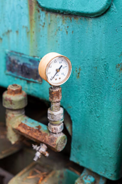 An old pressure gauge on some rusty old industrial equipment.