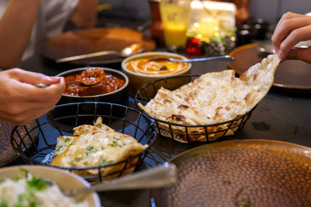 istock Sharing Garlic Naan with Butter Chicken at a Indian restaurant 2192267095
