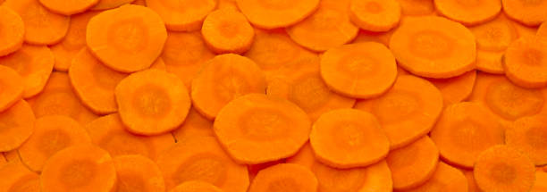 istock Orange background of fresh raw carrot slices 2192269819