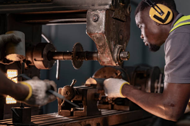 istock Focused industrial technician operating heavy machinery with precision. Wearing ear protection and safety gear, the professional works in a brightly lit workshop, emphasizing safety and expertise. 2192269893