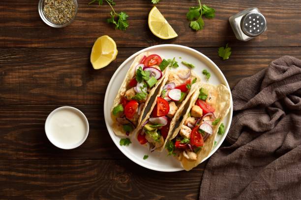 istock Tacos with vegetables and meat on wooden background 2192270457