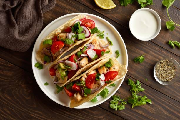istock Tacos with vegetables and meat on wooden background 2192270458