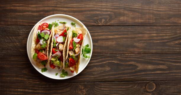 istock Tacos with vegetables and meat on wooden background 2192270462