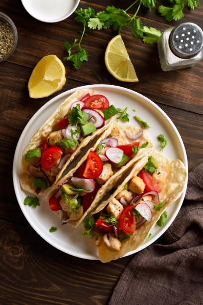 istock Tacos with vegetables and meat on white plate on wooden table 2192270463
