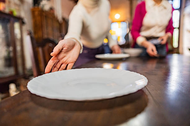 Close-up of woman setting the dinner table at home