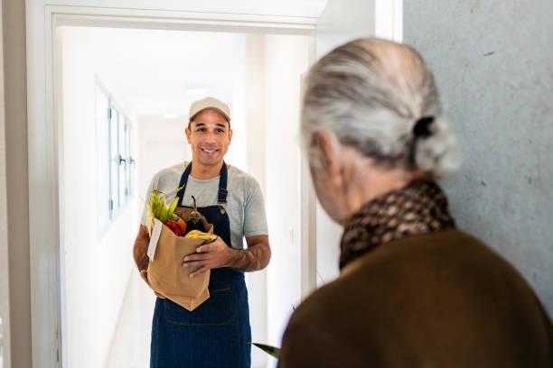istock Delivery person doing delivering vegetables to senior man 2192271622