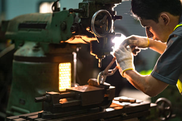 istock A skilled technician works attentively on a heavy duty machine in an industrial workshop. Dressed in safety gear, he demonstrates focus, precision, and craftsmanship in a professional environment. 2192271683