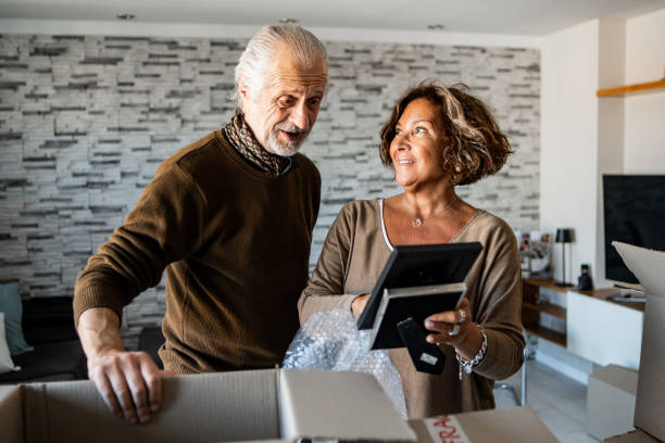 istock Senior woman showing a border frame to husband during home change 2192271703