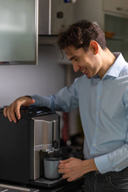 istock Young adult man preparing coffee with coffee machine in kitchen 2192272009