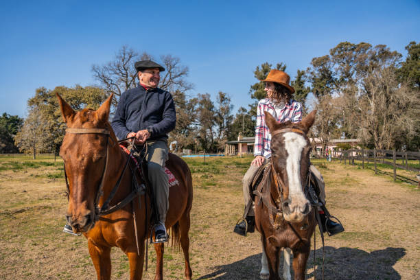 istock Father and daughter talking and riding horseback on a stable 2192272105