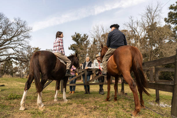 istock Family talking and riding horseback on a farm 2192272641