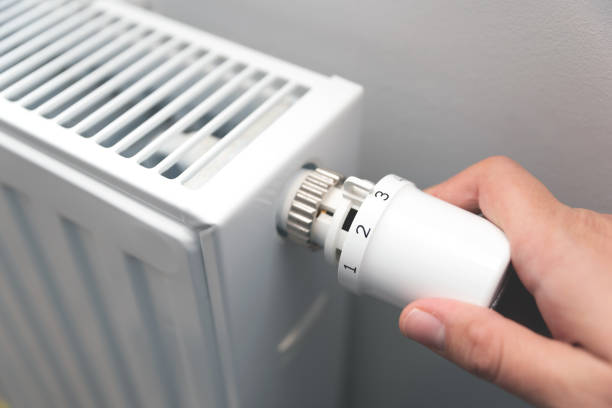 istock Person is adjusting the temperature on a radiator 2192272843
