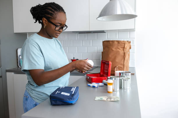 istock Young woman preparing emergency preparedness kits on a kitchen counter 2192273080