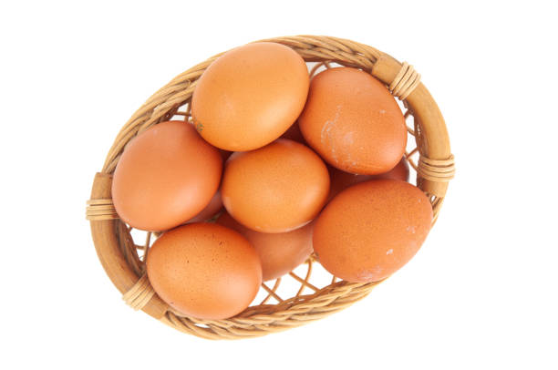 Brown eggs in wicker basket close up on a white background