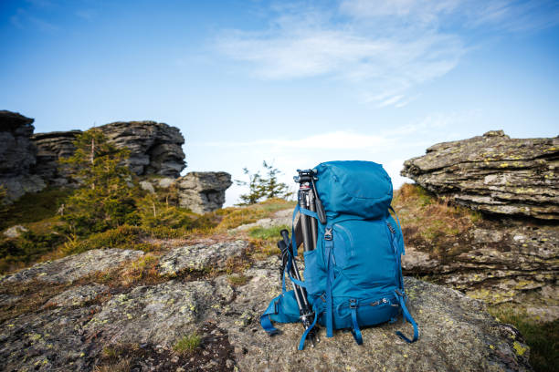 Backpack with tripod and hiking pole during trekking in mountains. Outdoor equipment for hike and trekking activity